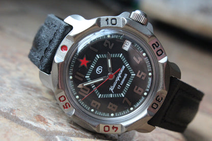 Vostok Komandirskie 816744 - diagonal front view with black geometric military emblem dial, complete case and crown, 12 oclock toward upper left