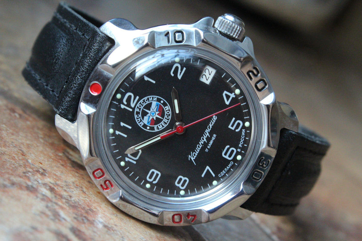 Vostok Komandirskie 811951 - diagonal front view with black EMERCOM emblem dial, complete case and crown