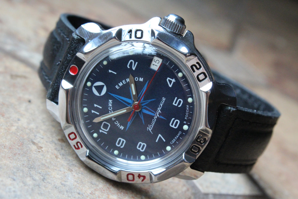 Vostok Komandirskie 811942 - diagonal front view with blue EMERCOM emblem dial, complete case and crown