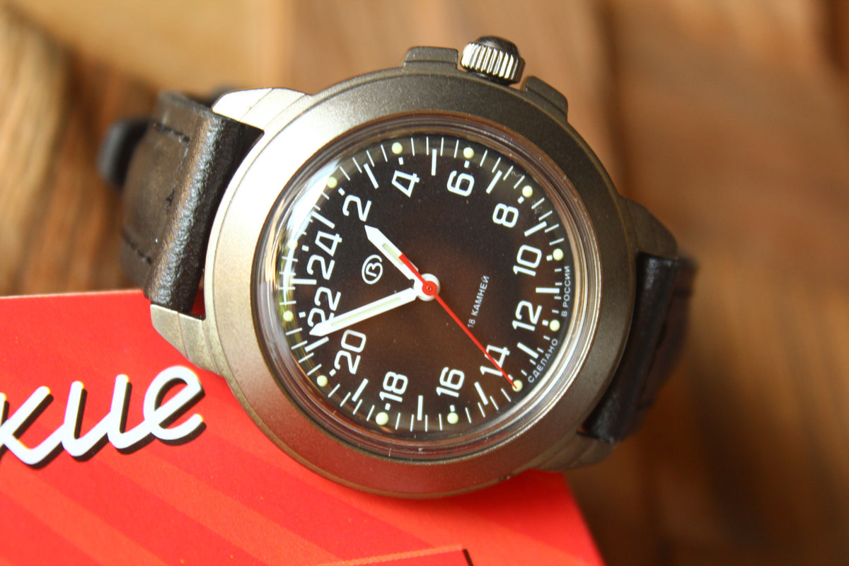 Vostok Komandirskie 43622G - diagonal front view of black 24-hour dial with leather strap